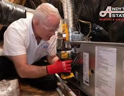 Technician servicing a furnace in a utility space