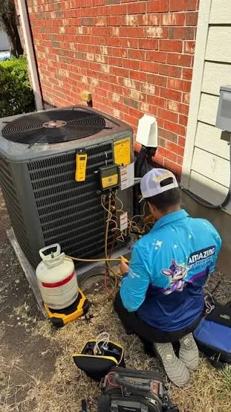 HVAC technician checking an outdoor unit with service gauges